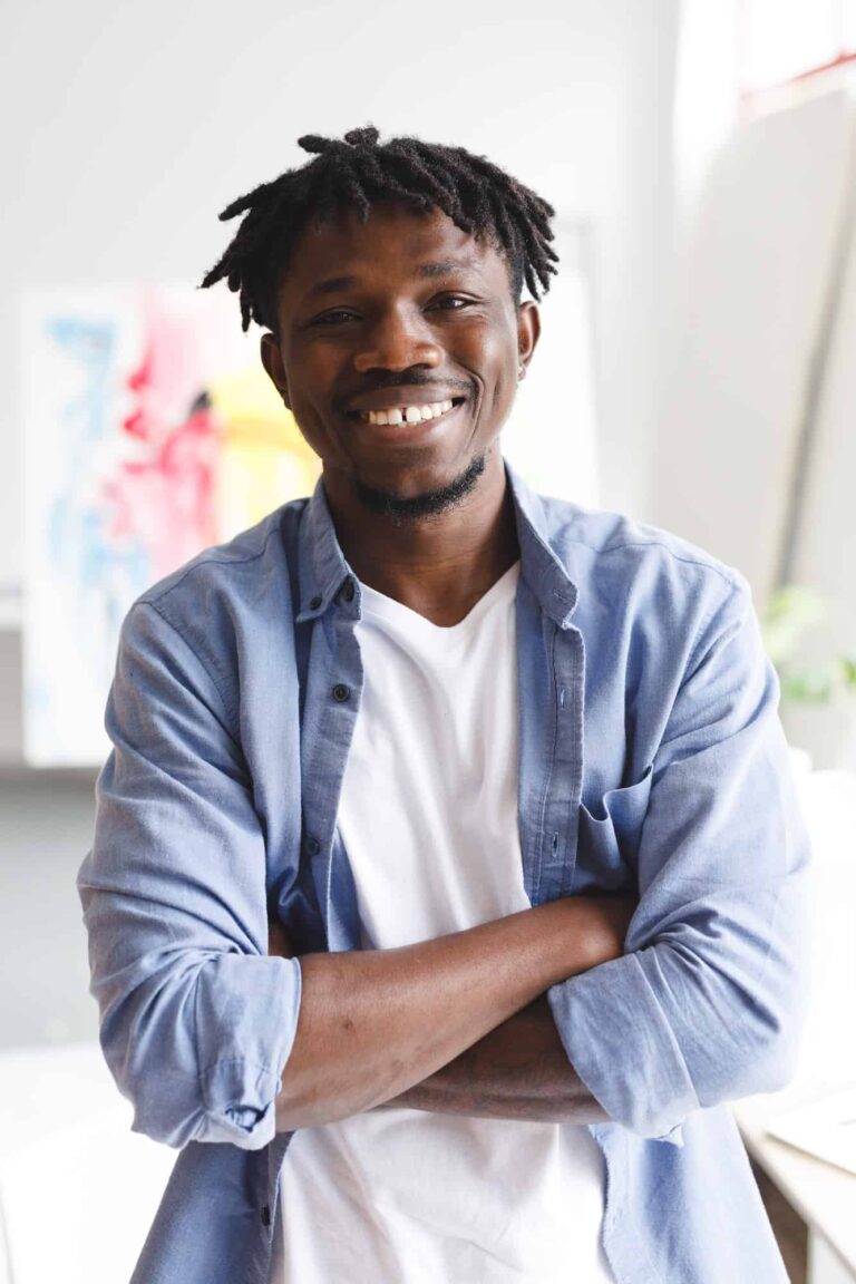 Portrait of smiling african american male painter at work looking at camera in art studio.jpg